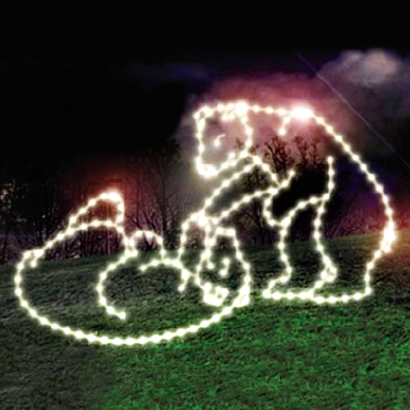 The image is of an LED display depicting two polar bear cubs playing. The image features bright white LED lights outlining the playful figures against a dark outdoor background with green trees and twilight sky colors. This Christmas bear decoration is a perfect addition to any holiday event.