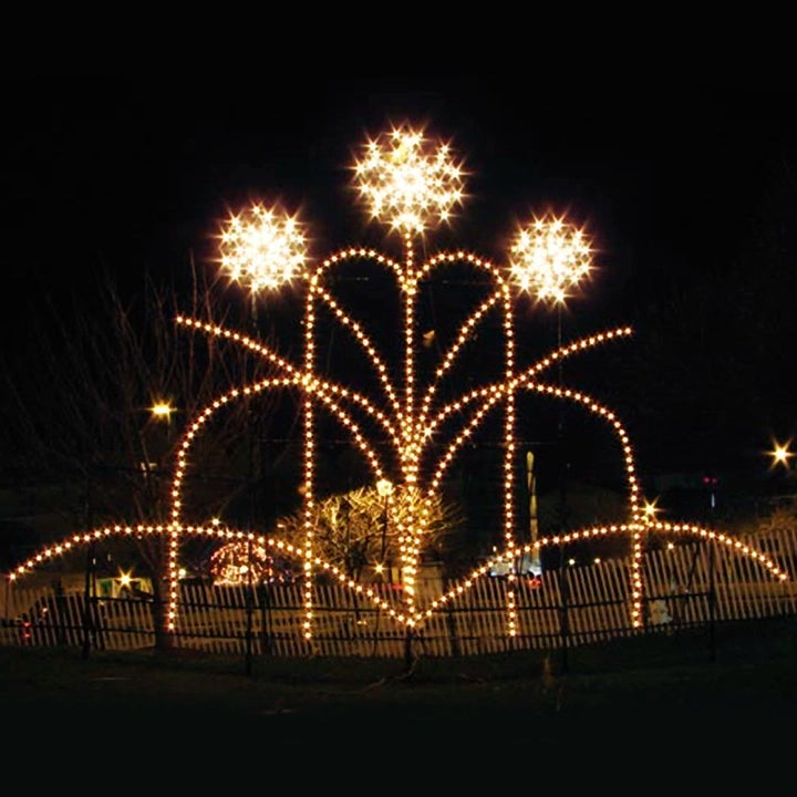 An illuminated display of a fountain made up of bright white LED lights. The structure features a series of arches with sparkling lights forming three star-like shapes at the top, creating a festive and elegant appearance against the night sky. The display is set outdoors, surrounded by a simple fence, and is likely part of a holiday or Christmas event.