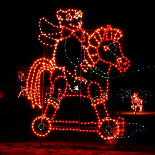 An animated silhouette LED display depicting a teddy bear riding a toy horse. The Christmas bear and toy horse are illuminated with bright red, green, and blue LED lights, set against a dark background, creating a festive and whimsical scene perfect for holiday events.