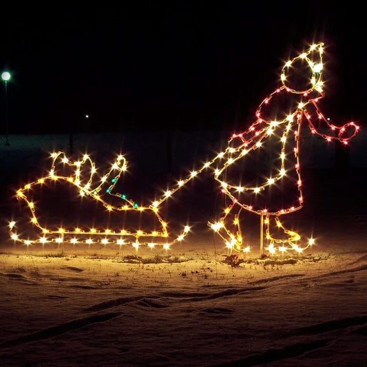 The image shows a brightly lit silhouette of a big sister pulling her younger sister in a sled, created with yellow, green, white and red LED lights. The LED display is set against a dark background, enhancing the warm glow of the lights. This Christmas silhouette is perfect for adding  vintage charm and holiday cheer to large and small event venues.