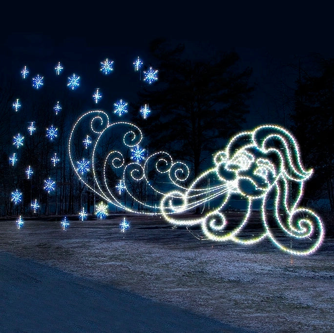 A Christmas silhouette LED display featuring a whimsical Old Man Winter character blowing snowflakes. The display includes bright white LED lights forming the character's face and beard, with swirling snowflake patterns illuminated by white and purple LED lights against a dark background.