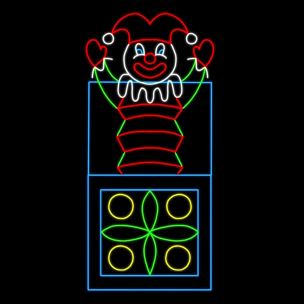 A vibrant animated LED silhouette display of a classic jack-in-the-box toy. The display features a cheerful clown popping out of a decorated box. The clown is dressed in a red and green outfit with a jester hat, smiling brightly with its arms raised. The box is adorned with colorful patterns, including yellow circles and green geometric shapes, all illuminated against a black background.