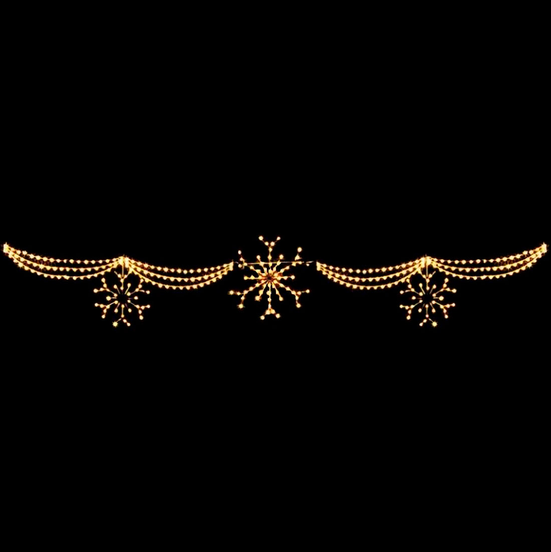 A skyline silhouette LED display featuring a central large snowflake pattern flanked by smaller snowflakes and draped with elegant, warm white LED lights creating a swag effect.