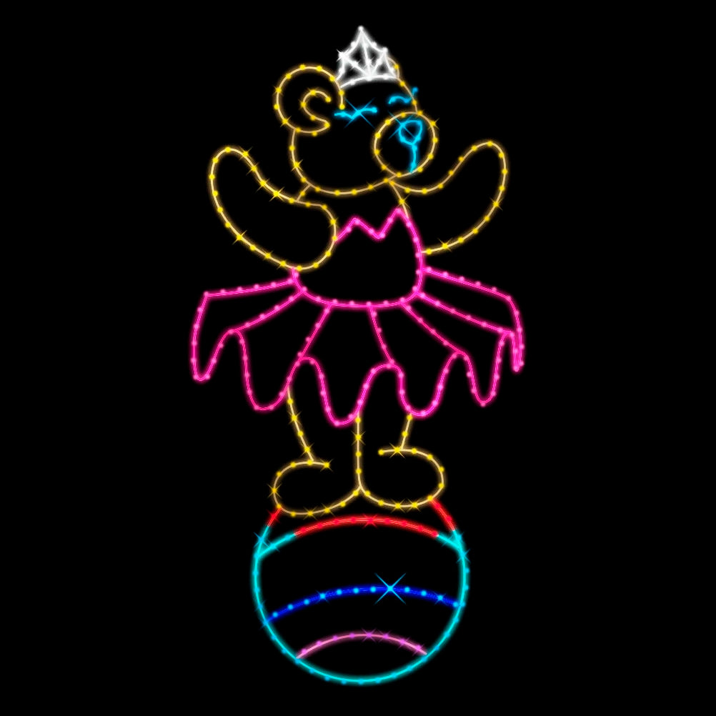 A colorful silhouette LED display featuring a teddy bear dressed in a pink tutu and a tiara, gracefully balancing on a multicolored ball. The display is illuminated with vibrant yellow, pink, blue, white, and teal LED lights, set against a dark background, creating a festive and enchanting scene for any occasion.
