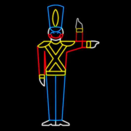 A brightly lit silhouette LED display of a toy soldier with a tall hat, animatedly pointing to the side. The soldier is outlined in vibrant colors: blue LED lights for the hat and pants, red LED lights for the arms and torso, yellow LED lights for the shoulders and belt, and white LED lights for the face and hands, set against a black background.